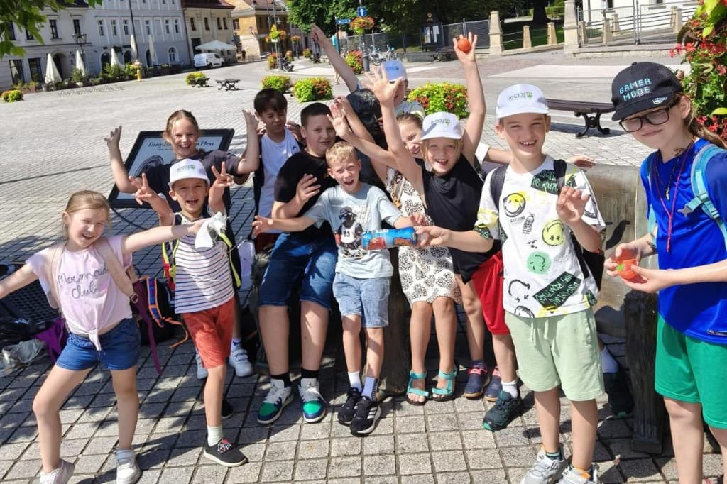 Uśmiechnięta grupa dzieci w czapkach Po Szkole na placu miasta